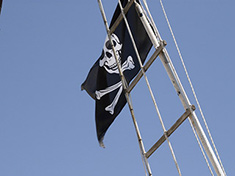 Na stěžni vlaje pirátská vlajka.
